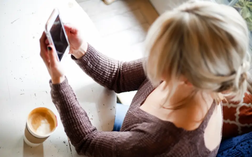Woman with coffee checking her phone